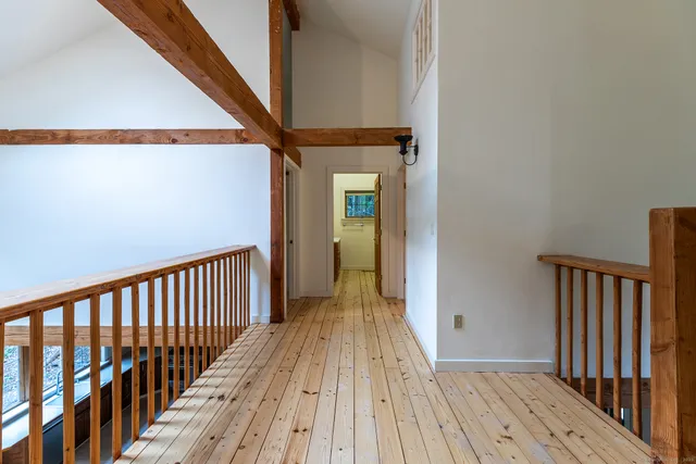 a view of a hallway with wooden floor and stairs