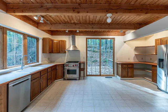 a kitchen with stainless steel appliances granite countertop a stove a sink and a refrigerator