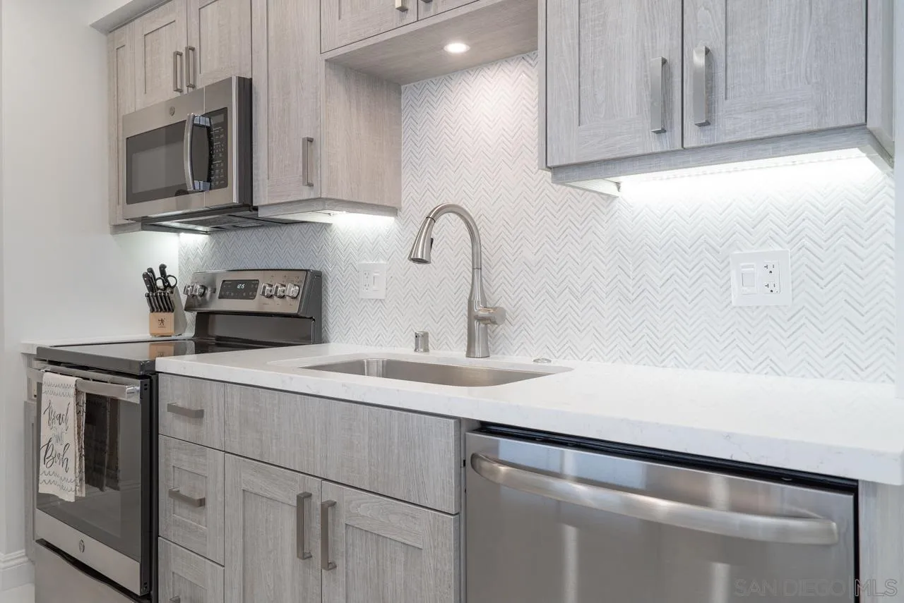 1770 Avenida Del Mundo, Unit 701 Coronado, CA 92118 - Photo 4 of 17 a kitchen with stainless steel appliances granite countertop a sink a stove microwave and cabinets