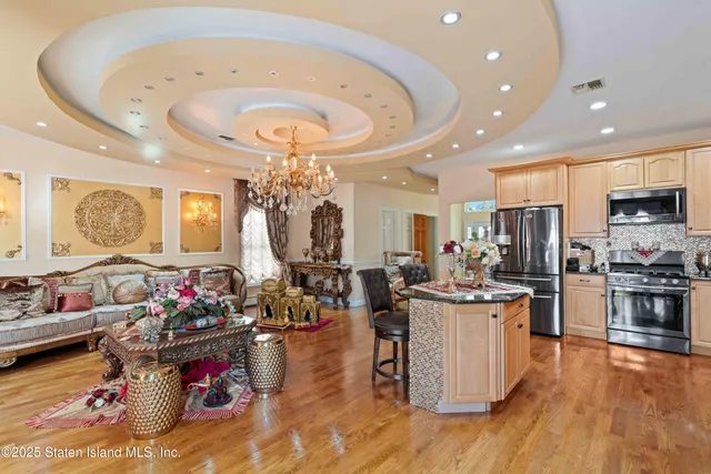 a kitchen with kitchen island stainless steel appliances a stove a sink a refrigerator and cabinets