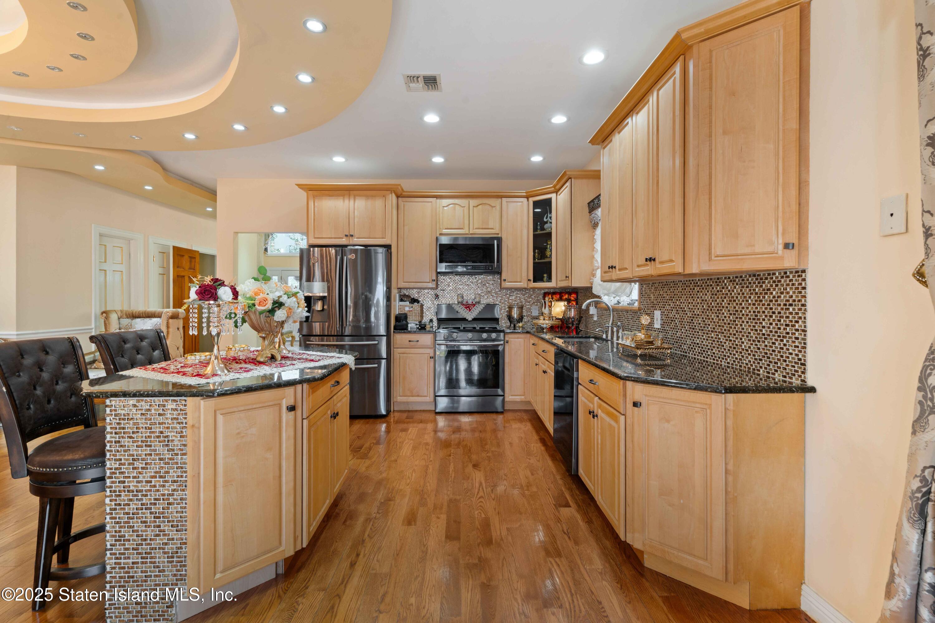 287 Rensselaer Avenue Staten Island, NY 10312 - Photo 14 of 35 a kitchen with kitchen island stainless steel appliances a stove a sink a refrigerator and cabinets