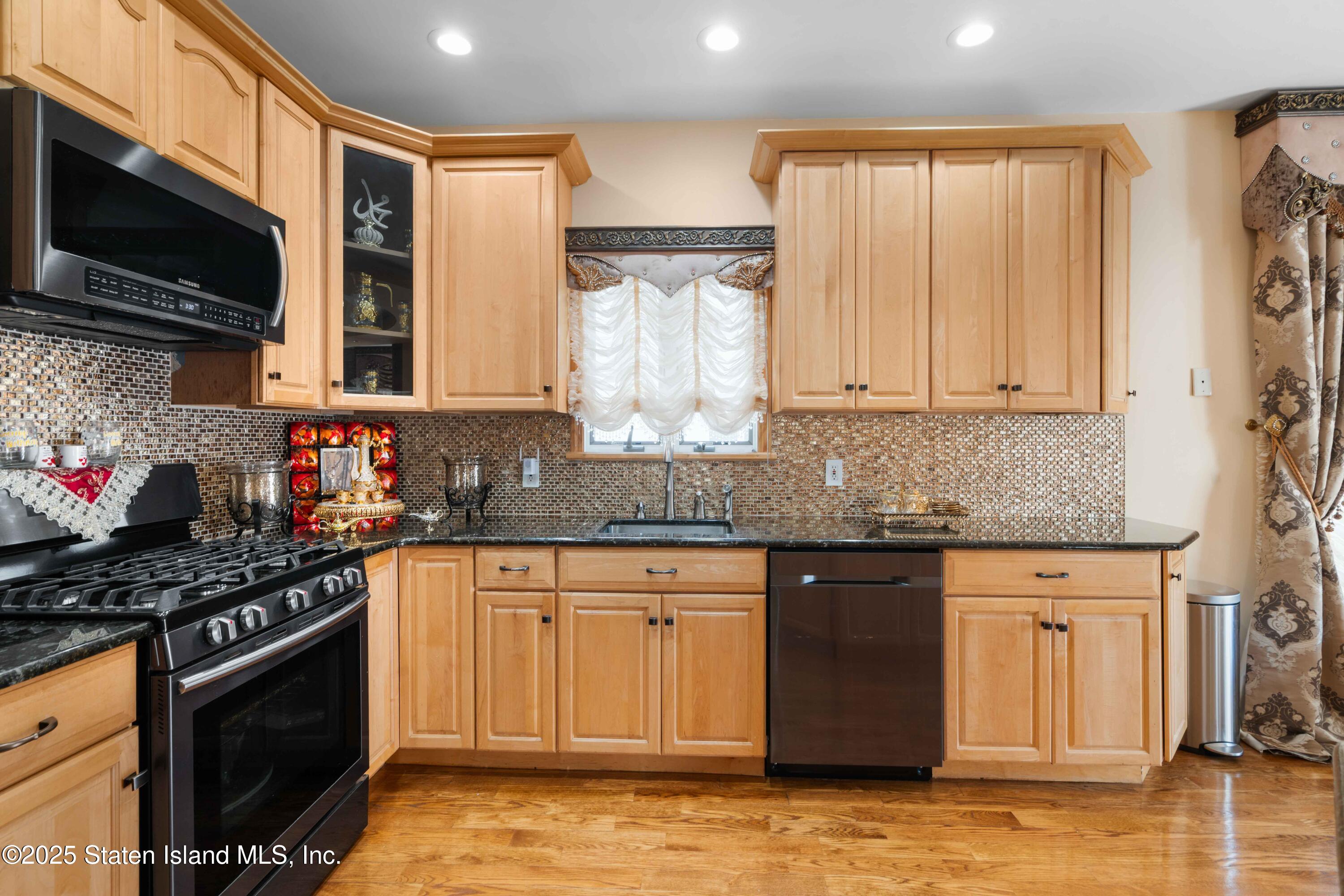 287 Rensselaer Avenue Staten Island, NY 10312 - Photo 15 of 35 a kitchen with stainless steel appliances granite countertop a stove a sink and a microwave