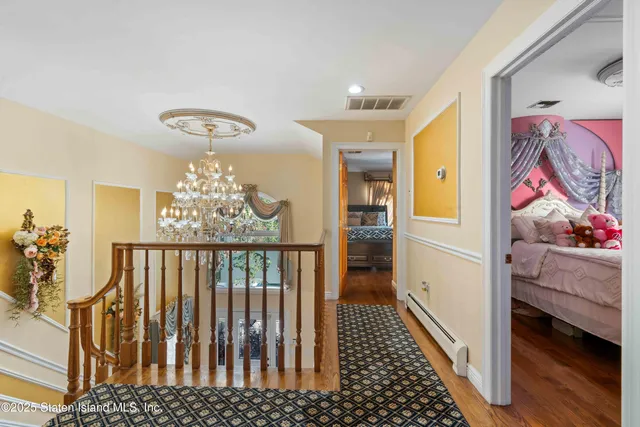 a view of a hallway with wooden floor and windows