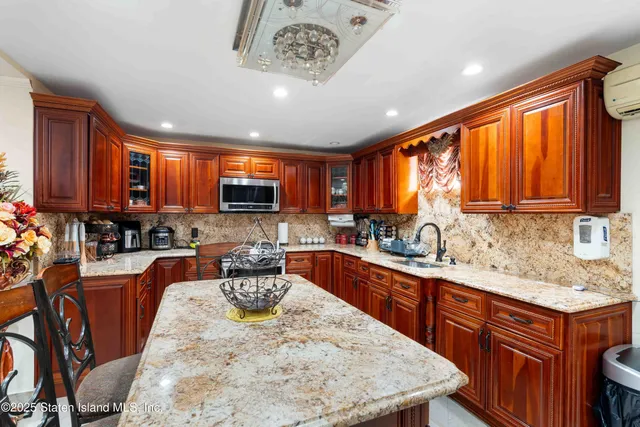 a large kitchen with stainless steel appliances granite countertop a stove oven a sink dishwasher and a dining table with garden view