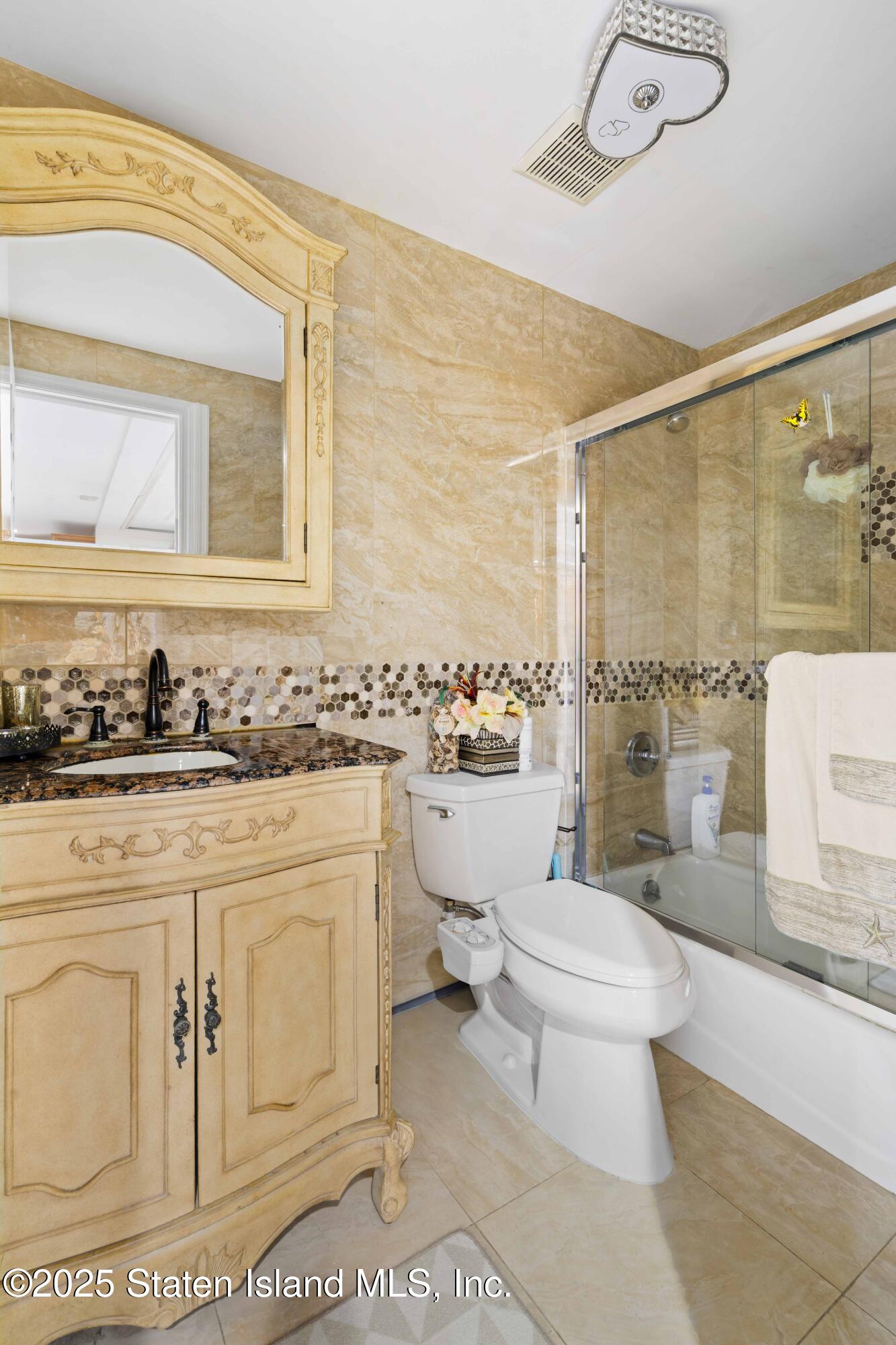 287 Rensselaer Avenue Staten Island, NY 10312 - Photo 34 of 35 a bathroom with a toilet sink and mirror