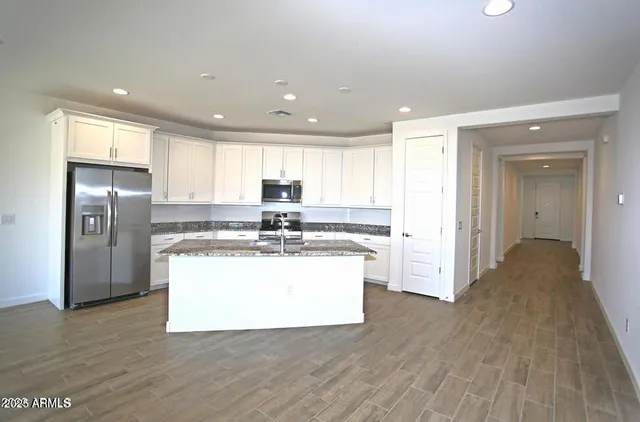 a kitchen with stainless steel appliances granite countertop a stove a sink and a refrigerator
