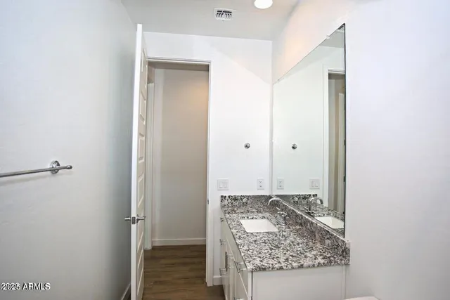 a bathroom with a granite countertop sink and a mirror