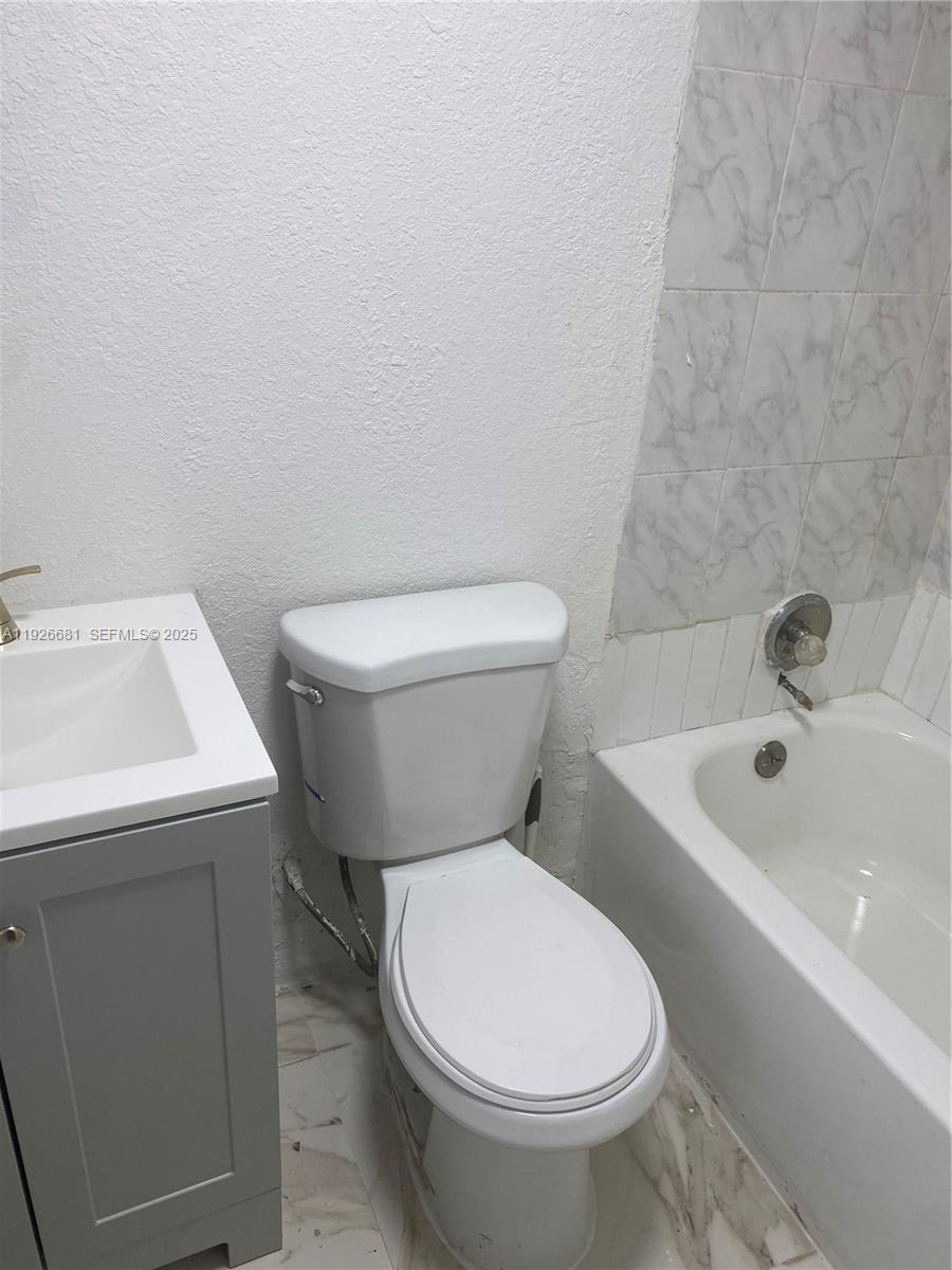 2122 Northwest 5th Street Pompano Beach, FL 33069 - Photo 27 of 53 a white toilet sitting next to a bathroom sink