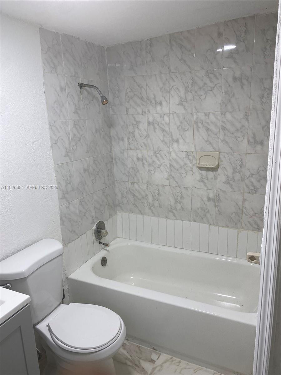 2122 Northwest 5th Street Pompano Beach, FL 33069 - Photo 32 of 53 a white bath tub sitting next to a toilet