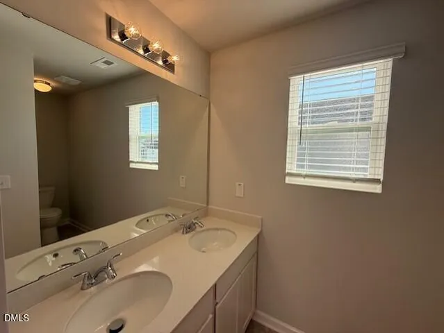 a spacious bathroom with a sink a toilet and shower