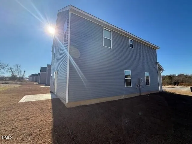 a view of a house with backyard and parking area