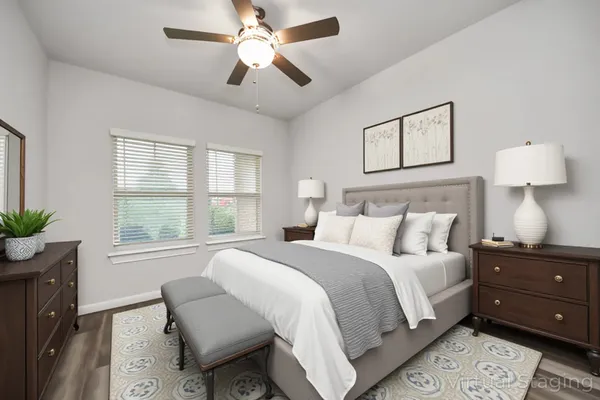 an empty room with wooden floor and ceiling fan