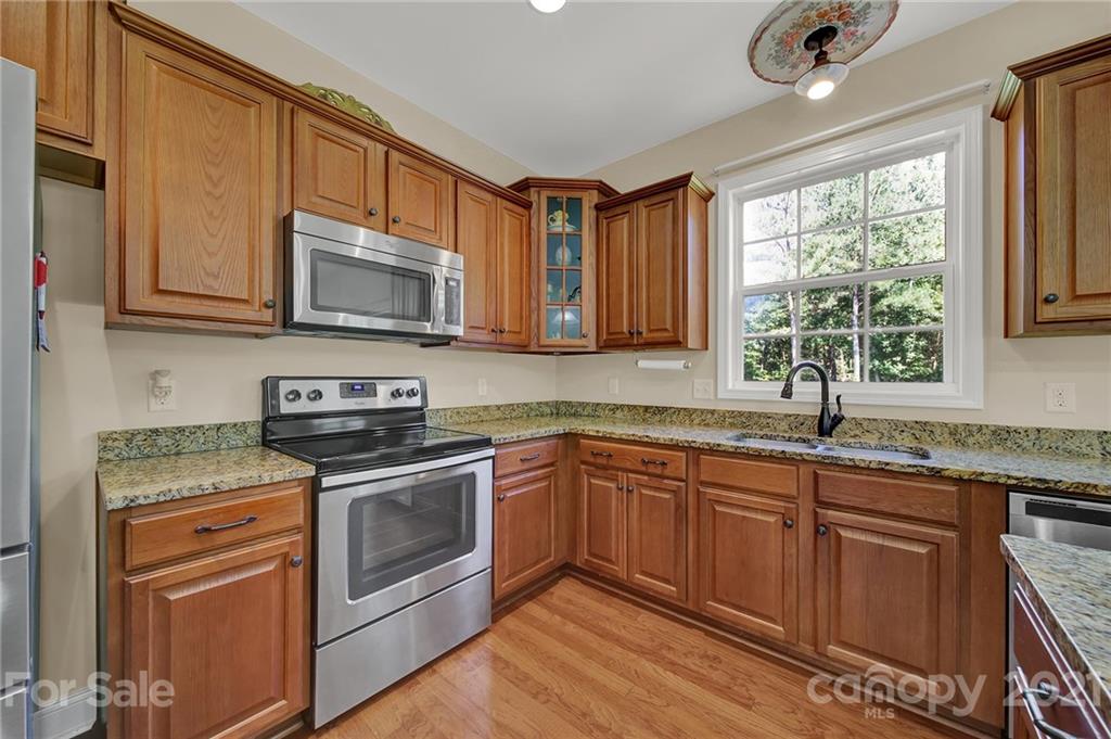 1185 Reservation Road Rock Hill, SC 29730 - Photo 17 of 47 a kitchen with granite countertop a sink stainless steel appliances cabinets and a window