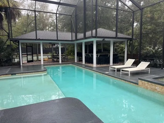 a view of a house with a backyard patio and swimming pool