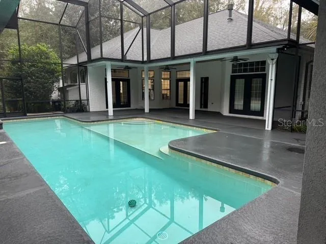 a view of a patio with a table and chairs and floor to ceiling window