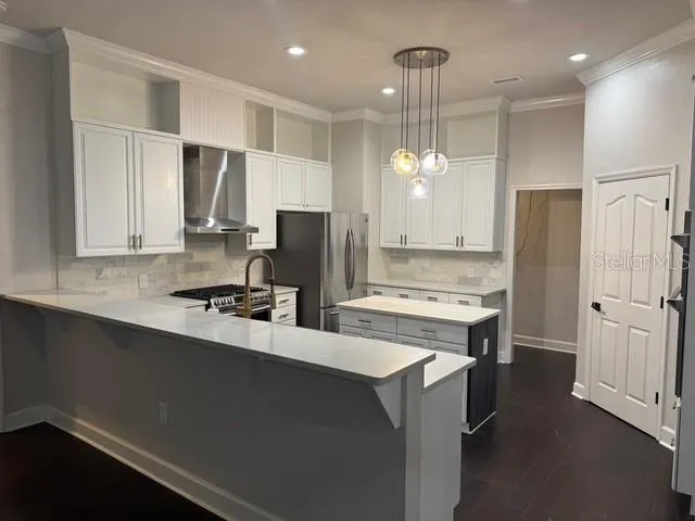 a kitchen that has a lot of cabinets and refrigerator