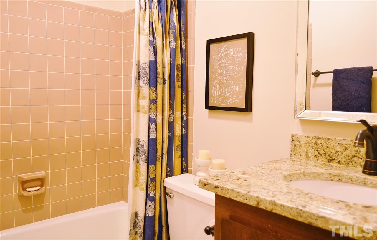 5200 Caber Road Raleigh, NC 27613 - Photo 15 of 25 a bathroom with a granite countertop sink a mirror and a shower