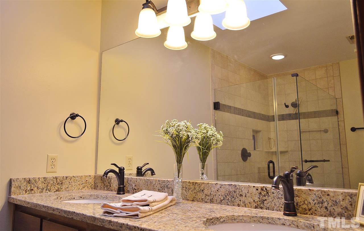 5200 Caber Road Raleigh, NC 27613 - Photo 18 of 25 a bathroom with a granite countertop sink a mirror and vanity