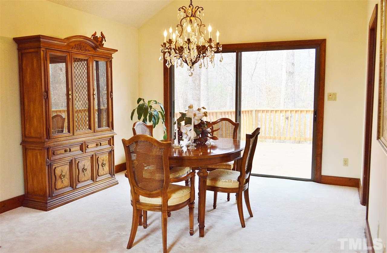 5200 Caber Road Raleigh, NC 27613 - Photo 6 of 25 a dining room with furniture a chandelier and wooden floor