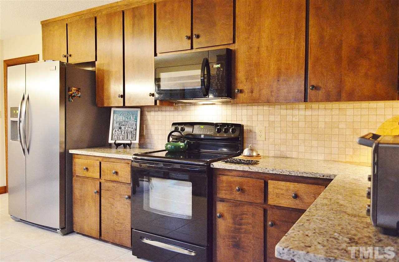 5200 Caber Road Raleigh, NC 27613 - Photo 9 of 25 a kitchen with stainless steel appliances granite countertop a stove a refrigerator and a sink