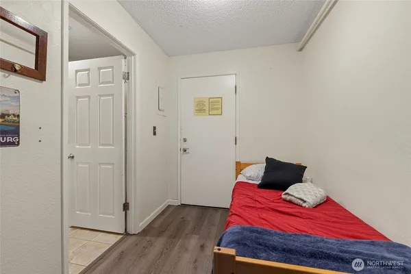 a bedroom with a bed and wooden floor