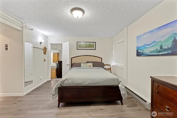 a spacious bedroom with a bed and a painting on the wall