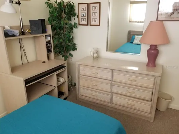 a bedroom with a bed tv and a window
