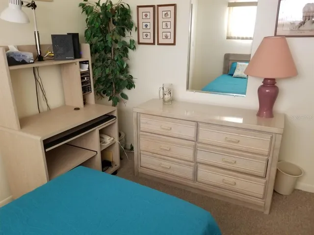 a bedroom with a bed tv and a window