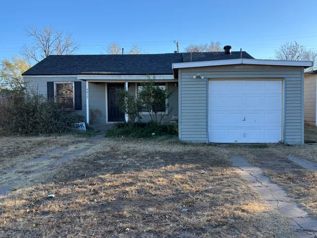a view of a house with a yard and garage