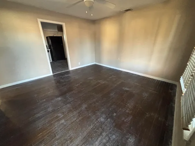 an empty room with wooden floor and closet