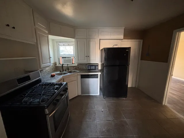 a kitchen with a refrigerator stove and cabinets