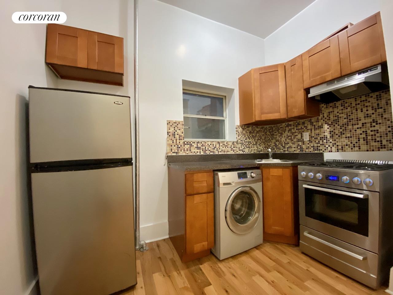a kitchen with a refrigerator and a washer dryer