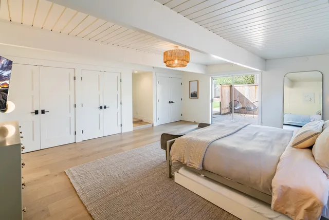 a bedroom with a bed and a painting on the wall