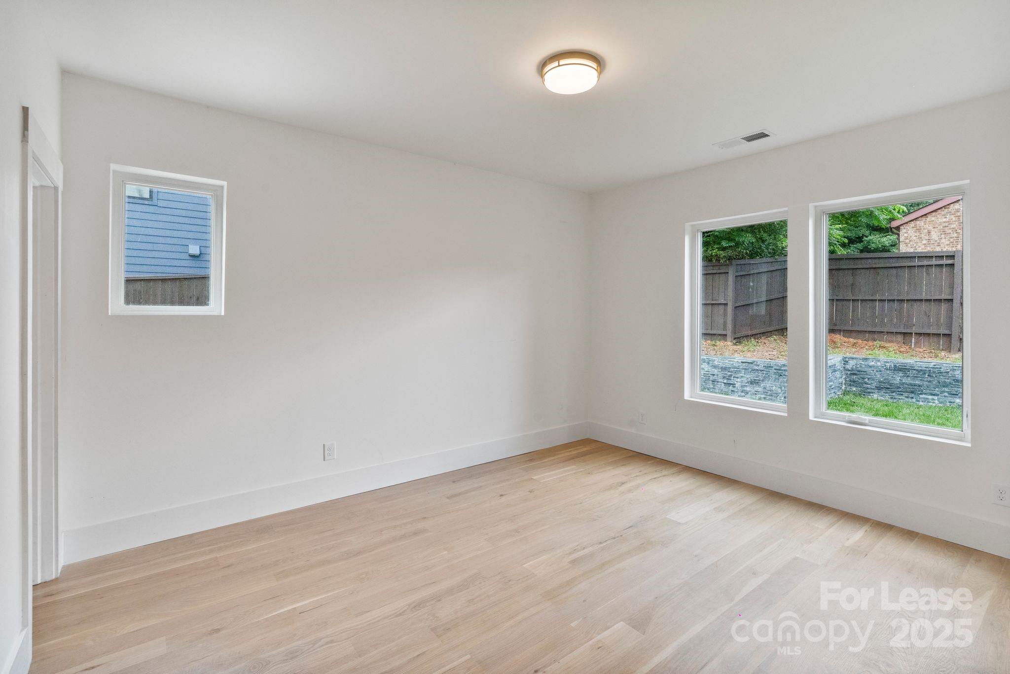 129 French Street, Unit B Charlotte, NC 28216 - Photo 11 of 32 an empty room with wooden floor and windows