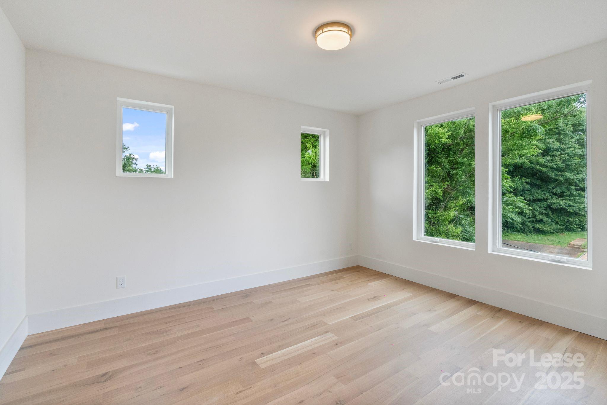 129 French Street, Unit B Charlotte, NC 28216 - Photo 14 of 32 an empty room with wooden floor and windows