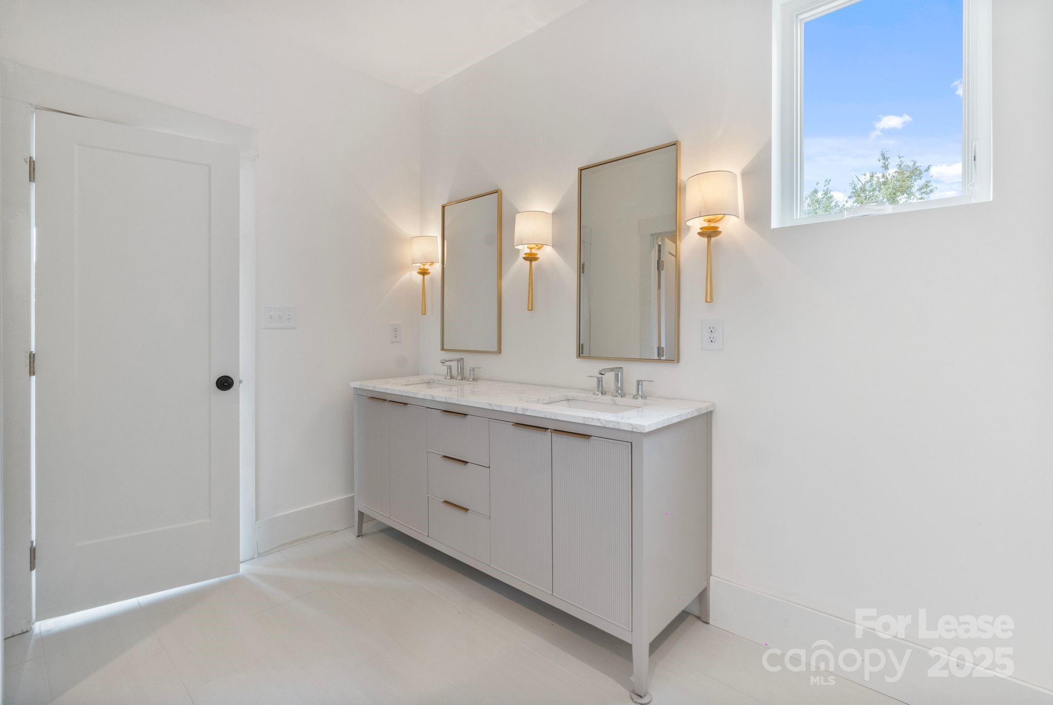 129 French Street, Unit B Charlotte, NC 28216 - Photo 17 of 32 a bathroom with a double vanity sink and a mirror