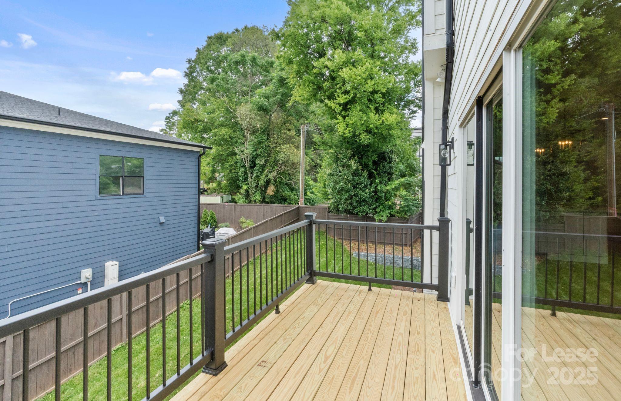 129 French Street, Unit B Charlotte, NC 28216 - Photo 24 of 32 a view of a wooden balcony and trees