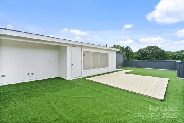 a view of an house with backyard space and balcony