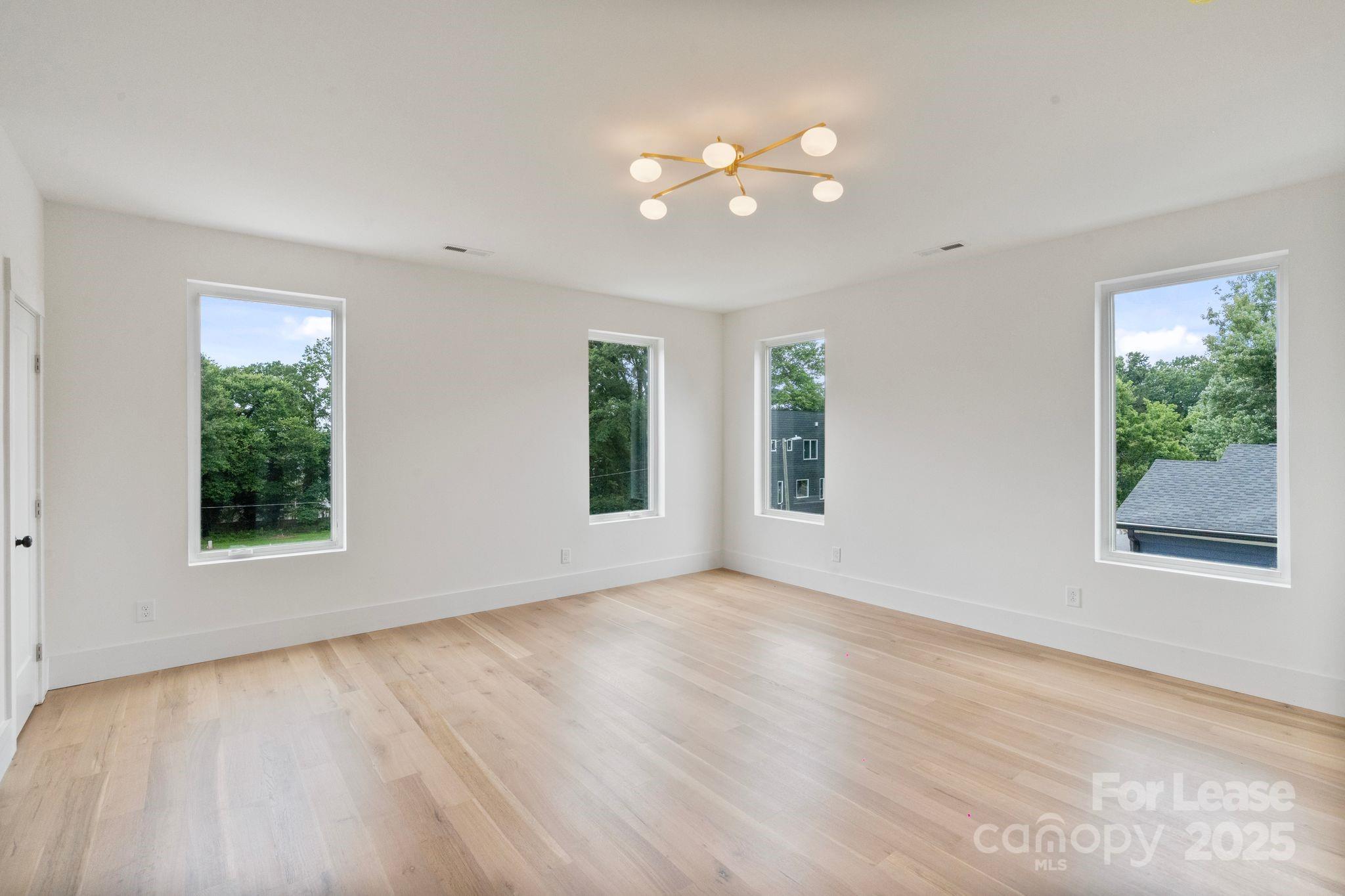 129 French Street, Unit B Charlotte, NC 28216 - Photo 7 of 32 a view of an empty room with wooden floor and a window