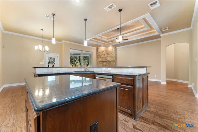 a kitchen with a refrigerator a sink and wooden floor