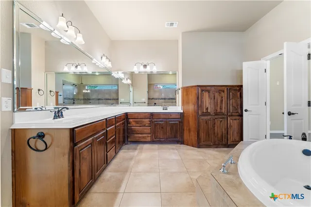 a large kitchen with a large counter top a sink a stove a refrigerator and a mirror