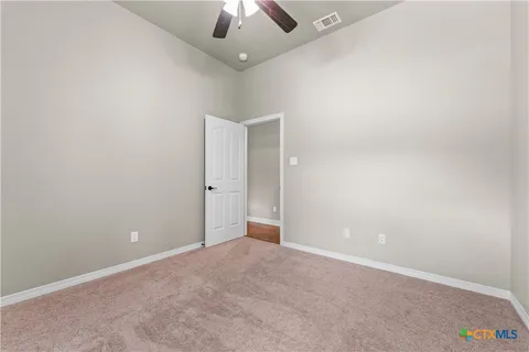 an empty room with a ceiling fan and a window