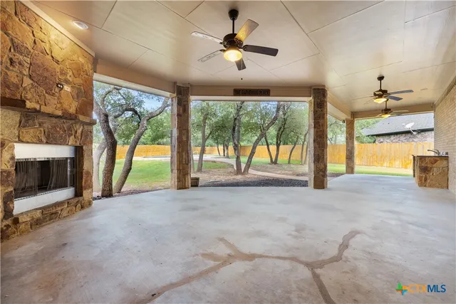 a view of an empty room with a fireplace and a chandelier