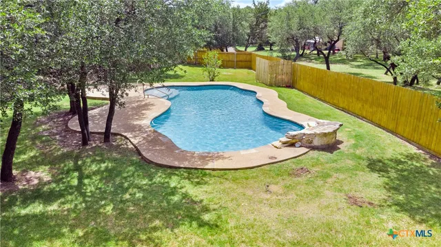a view of a swimming pool with an outdoor seating and a forest