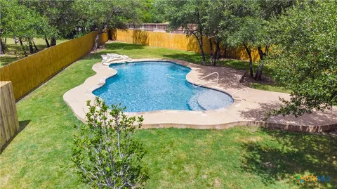 a view of a backyard with swimming pool