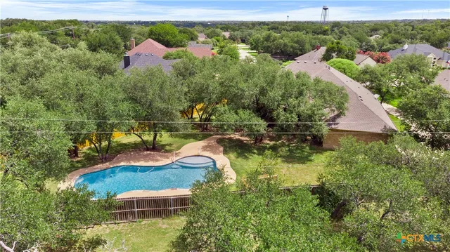 an aerial view of residential houses with outdoor space and swimming pool