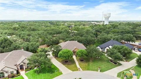 an aerial view of a house with a yard and lake view