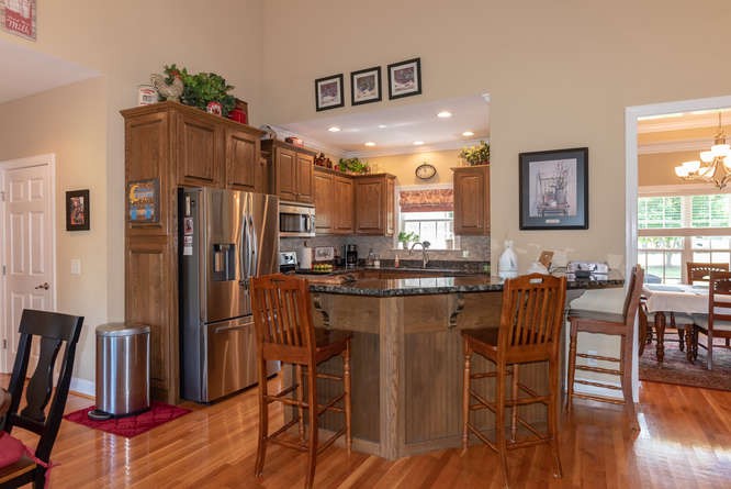 1997 Clara Mathis Road Spring Hill, TN 37174 - Photo 14 of 47 a kitchen with stainless steel appliances granite countertop a refrigerator a stove a sink a dining table and chairs with wooden floor
