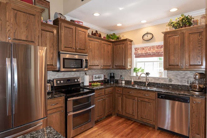 1997 Clara Mathis Road Spring Hill, TN 37174 - Photo 2 of 47 a kitchen with granite countertop a refrigerator stove and sink with wooden floor