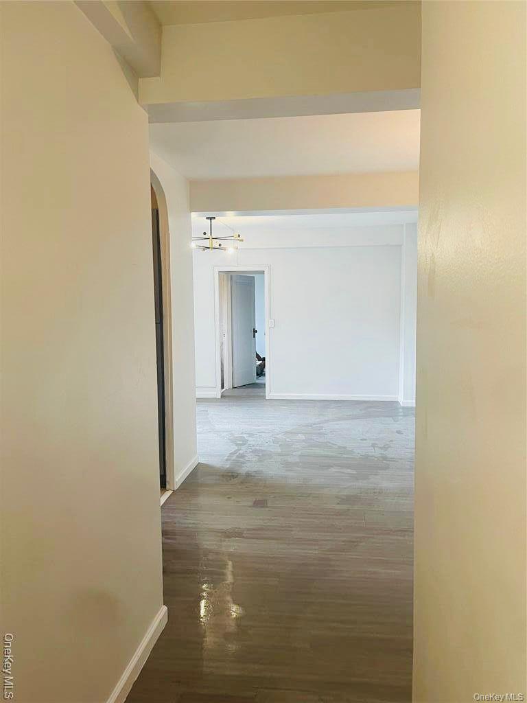 5-metropolitan Oval, Unit 4H Bronx, NY 10462 - Photo 3 of 4 Corridor featuring arched walkways and light wood-style floors